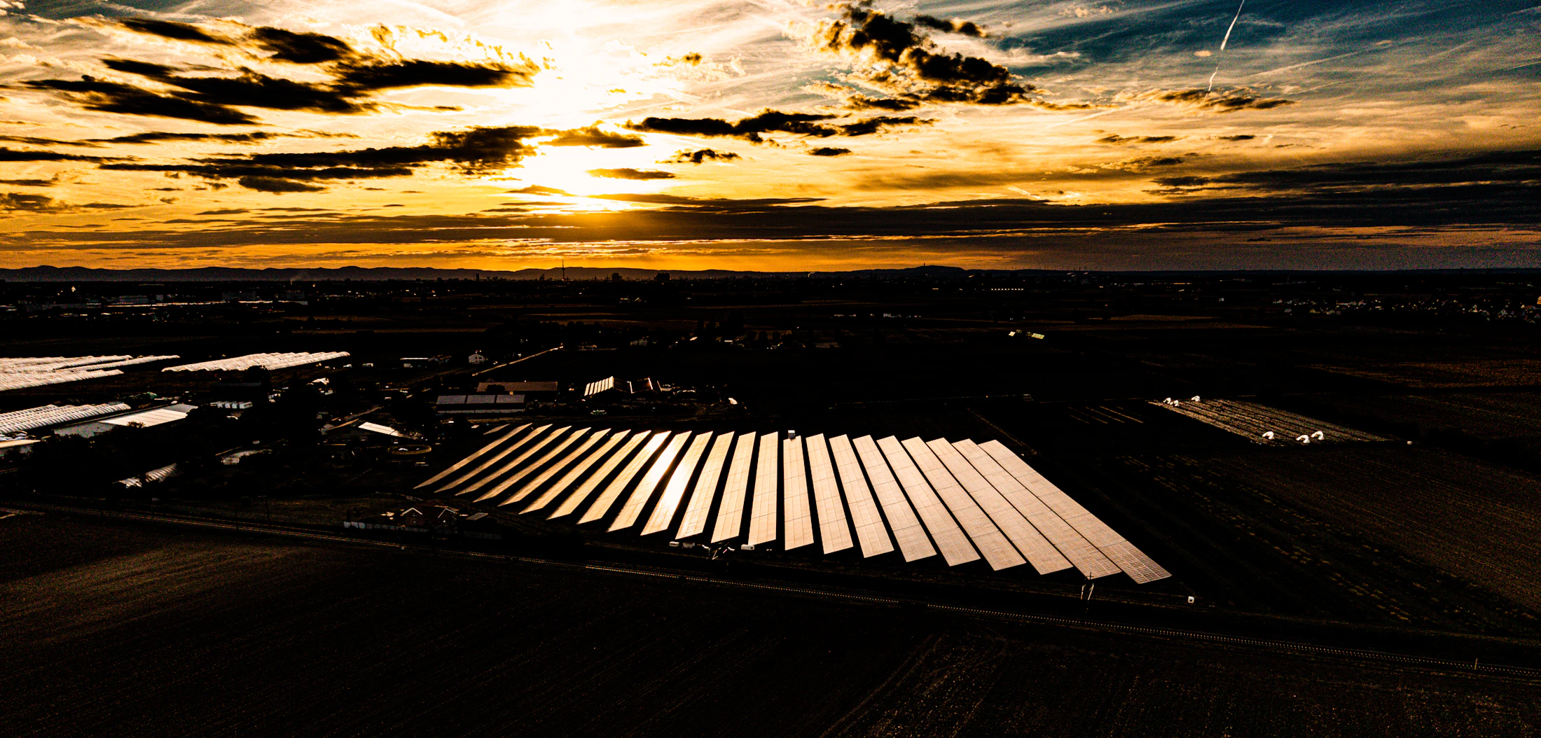 Solar panels across a broad landscape at dusk